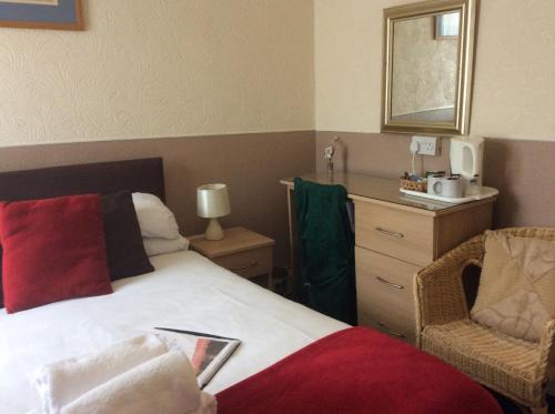 Habitación de hotel con cama y silla en The Aberford, en Blackpool