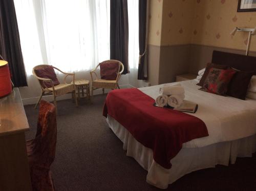 um quarto de hotel com uma cama com toalhas em The Aberford em Blackpool