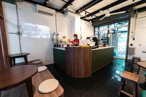 a woman standing at the counter of a restaurant at Canal View Lo-ha guest house, Contactless Check-in in Bangkok