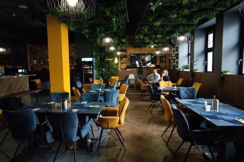 un restaurante con mesas y sillas con gente sentada a su lado en R73 Residences, en Pécs
