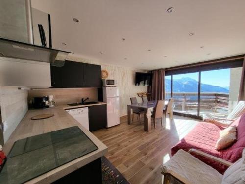 Il comprend une cuisine et un salon avec une table. dans l'établissement Appartement Rez de chaussée 6pers 2chambres Pieds d une remontée et à 300m des pistes, à Orcières