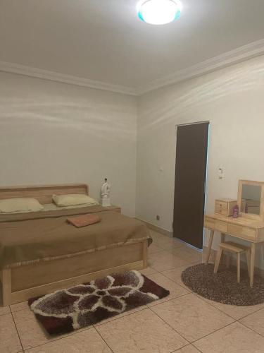 um quarto com uma cama e uma mesa com um tapete em Studio meuble sacre cœur em Dakar