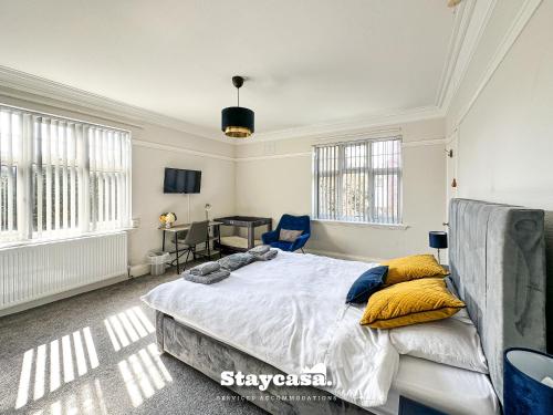 1 dormitorio con 1 cama grande con almohadas amarillas en Stunning 5bdr Detached King Suite Abode, en Leicester