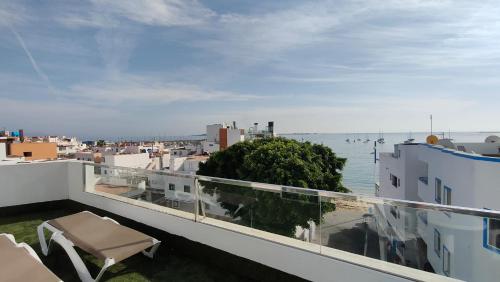 a balcony with a view of the ocean and buildings at 4rooms Fuerteventura in Corralejo