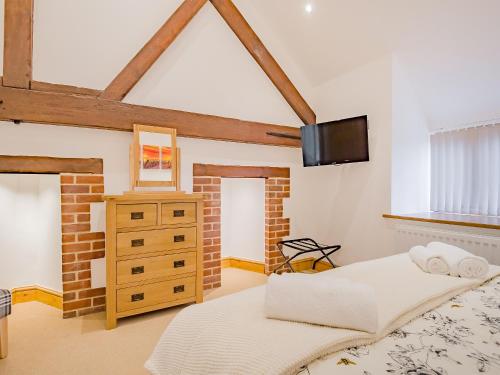 a bedroom with two beds and a tv on the wall at The Great South Barn - Ukc2527 in Trunch
