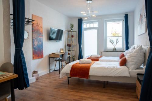 a bedroom with a bed and a desk and a window at Volante Apartment Bremen-Findorff in Bremen