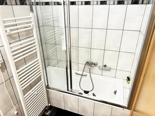 a shower in a white tiled bathroom at Gtrip Nea Smyrni Floor Apartment 7F in Athens