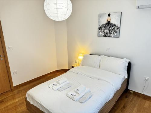 een slaapkamer met een bed met twee handdoeken erop bij Gtrip Nea Smyrni Floor Apartment 7F in Athene
