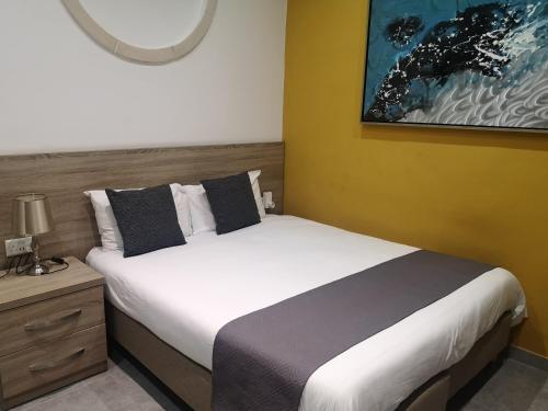 a bedroom with a large bed and a nightstand with a bed sidx sidx sidx at Dghajsa GUEST HOUSE in Senglea