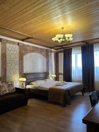 ein Schlafzimmer mit einem großen Bett und einer Decke in der Unterkunft Taras Bulba in Kamjanez-Podilskyj