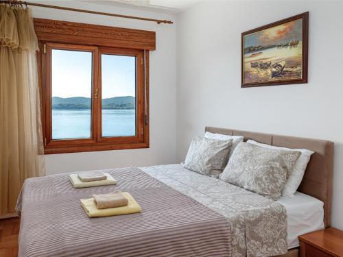 a bedroom with a bed with two towels on it at Tivat Center SeaView Apartment in Tivat