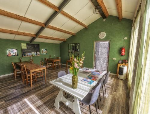 een eetkamer met groene muren en een tafel en stoelen bij Het Gelders Buitenleven in Overasselt