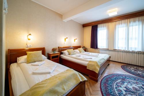 a hotel room with two beds and a window at Lilla Panzió in Odorheiu Secuiesc