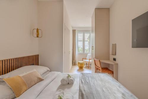 ein weißes Schlafzimmer mit einem Bett und einem Tisch in der Unterkunft NEW Luxury & Cozy Apartment - 6p in Paris