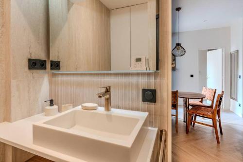 ein weißes Waschbecken in einer Küche mit einem Tisch in der Unterkunft NEW Luxury & Cozy Apartment - 6p in Paris
