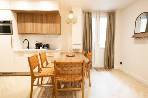 - une cuisine avec une table à manger et des chaises dans l'établissement NEW Luxury & Cozy Apartment - 6p, à Paris