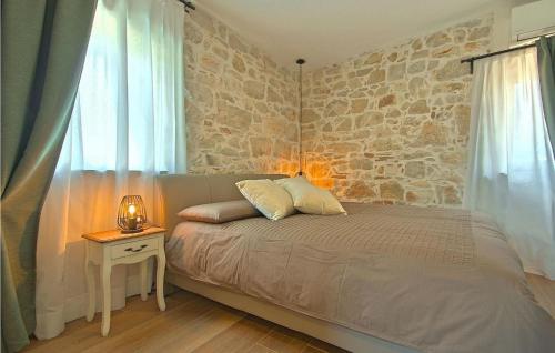 - une chambre avec un lit et un mur en pierre dans l'établissement Villa M, à Poreč