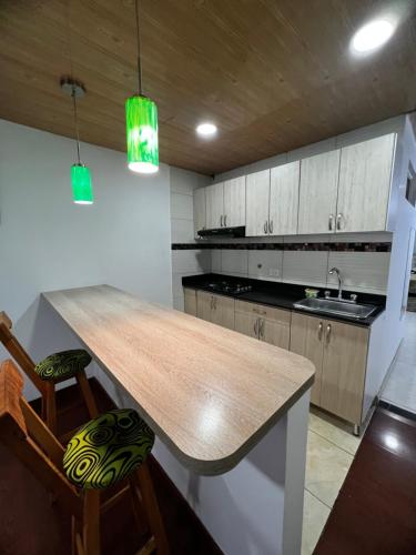 a kitchen with a wooden counter top and wooden cabinets at Welcome to Bogota 2 in Bogotá