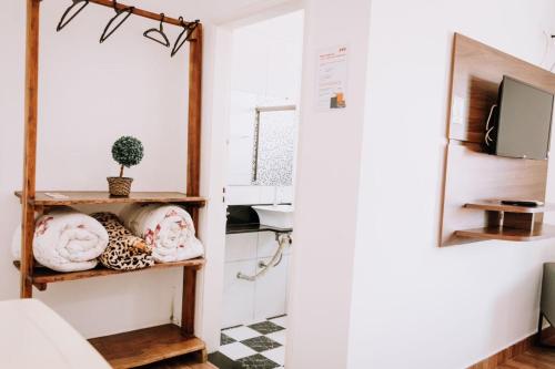 a room with a sink and a shelf with towels at Hotel Novo Horizonte in Monte Sião
