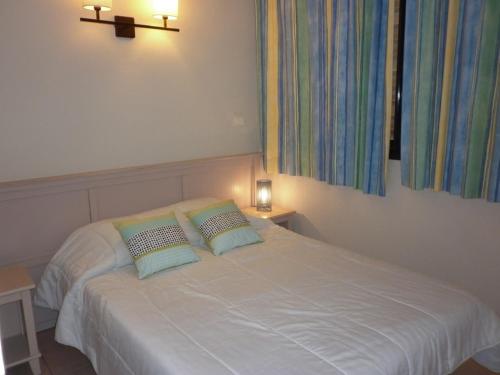 une chambre avec un lit blanc avec deux oreillers dans l'établissement 3 pièces avec grande terrasse vue mer Rochelongue Cap d'Agde, au Cap d'Agde