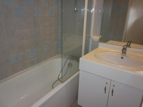 une salle de bain avec un lavabo et une douche en verre dans l'établissement 3 pièces avec grande terrasse vue mer Rochelongue Cap d'Agde, au Cap d'Agde