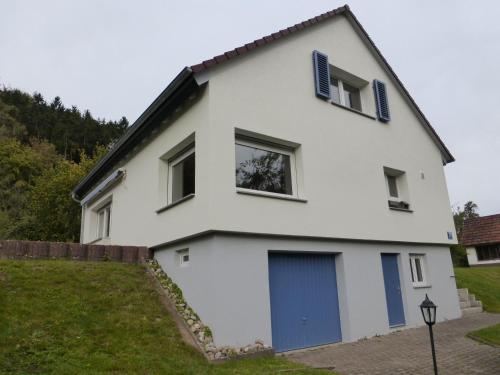 een wit huis met blauwe luiken erop bij Ferienhaus Ernas Hygge 