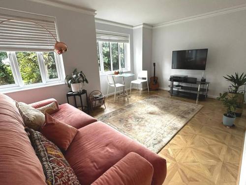 a living room with a couch and a flat screen tv at Stylish, Peaceful 2-Bed Flat with Free Parking in New Barnet
