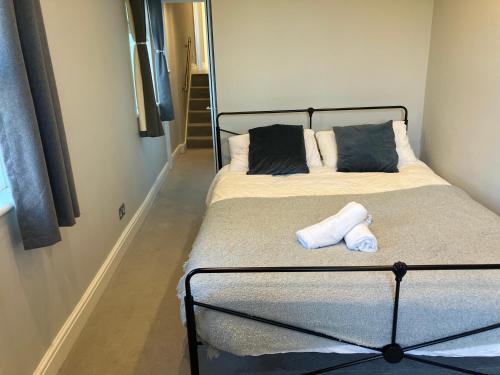a bedroom with a bed with two pillows at Splendid 2 Bed Flat with Private Terrace in Wimbledon - 2 The Queens in London