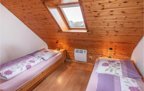 2 camas en una habitación pequeña con ático en Ferienhaus Trischenblick, en Friedrichskoog