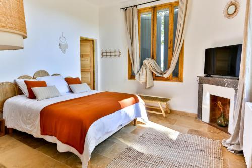um quarto com uma cama grande e uma lareira em Villa Montel - Havre de paix à Graveson em Graveson