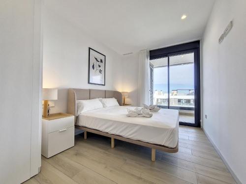 - une chambre blanche avec un lit et une grande fenêtre dans l'établissement Santa Rosalia Lake & Life Resort - 1310, à Torre-Pacheco
