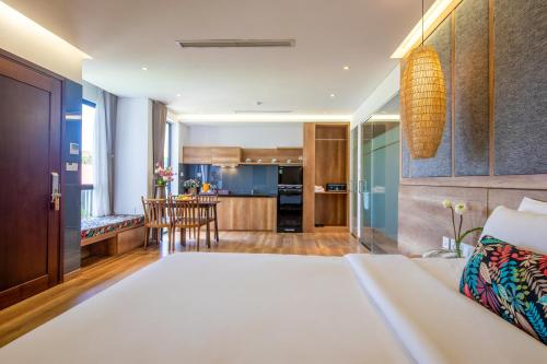 a living room and kitchen with a bed and a table at K House Apartment Danang Beach in Da Nang