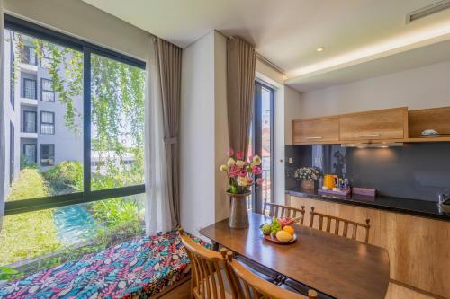 a dining room with a table and a large window at K House Apartment Danang Beach in Da Nang