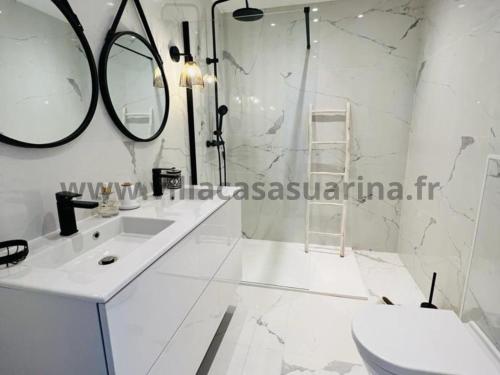 une salle de bain blanche avec un lavabo et un miroir dans l'établissement Villa vue mer, piscine chauffée à Porto Vecchio, à Porto-Vecchio