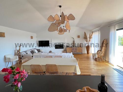 un salon avec une table blanche et un canapé dans l'établissement Villa vue mer, piscine chauffée à Porto Vecchio, à Porto-Vecchio