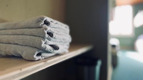 a pile of towels sitting on top of a counter at Hotel Alpina Einhorn - Self-Check-In in Wolfenschiessen