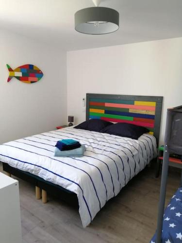 - une chambre avec un grand lit et une tête de lit colorée dans l'établissement Villa de la plage des Amiets #piscine intérieure privée# les pieds dans l'eau, à Cléder