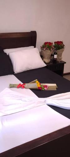 uma cama com flores e um livro sobre ela em Hotel YURA y YANA em Quito