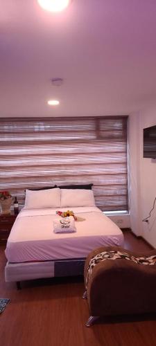 um quarto com uma cama grande e uma janela em Hotel YURA y YANA em Quito