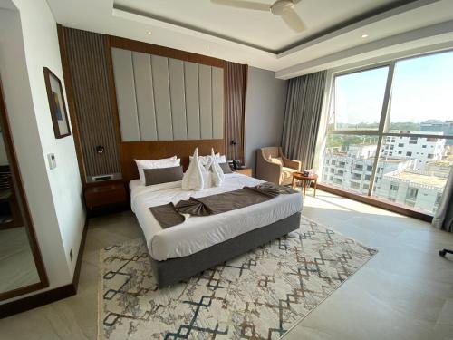 a hotel room with a bed and a large window at Hotel Windy Terrace in Cox's Bazar