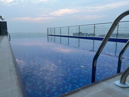 a swimming pool with blue water and a fence at Hotel Windy Terrace in Cox's Bazar
