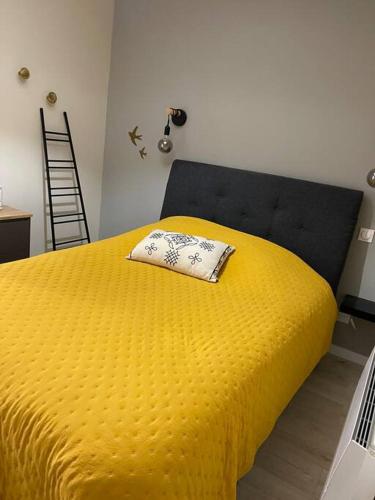 - un lit jaune avec un oreiller dans l'établissement Très bel appt en centre ville, à Le Touquet-Paris-Plage