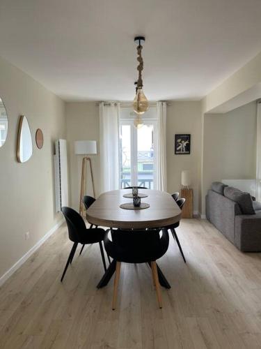 un salon avec une table, des chaises et un canapé dans l'établissement Très bel appt en centre ville, à Le Touquet-Paris-Plage