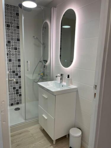 une salle de bain blanche avec un lavabo et une douche dans l'établissement Très bel appt en centre ville, à Le Touquet-Paris-Plage