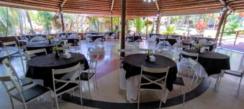 - un groupe de tables et de chaises dans une tente dans l'établissement RESORT CHALÉ DA PRATA, à Curvelo