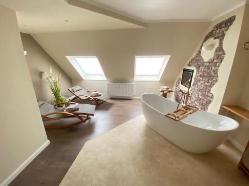 Łazienka z dużą białą wanną na poddaszu w obiekcie Dagmar 120qm 3 Schlafzimmer Wellness w mieście Olsberg