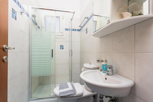a white bathroom with a sink and a shower at Amphitrite Villa in Gennadi