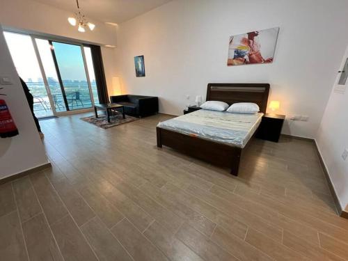 a bedroom with a bed in a room with large windows at Furnished & Serviced Studio in Abu Dhabi