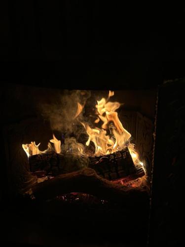 a fireplace filled with fire in the dark at Moulin de Joumard, gîtes, chambres et table d'hôtes de charme , jacuzzi, sauna, piscine et bain nordique Etablissement 4 étoiles in Aubazat