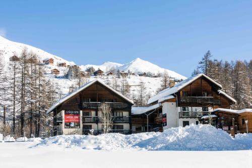 un lodge de ski dans les montagnes avec de la neige au sol dans l'établissement Hotel Spa L'Equipe, à Molines-en-Queyras
